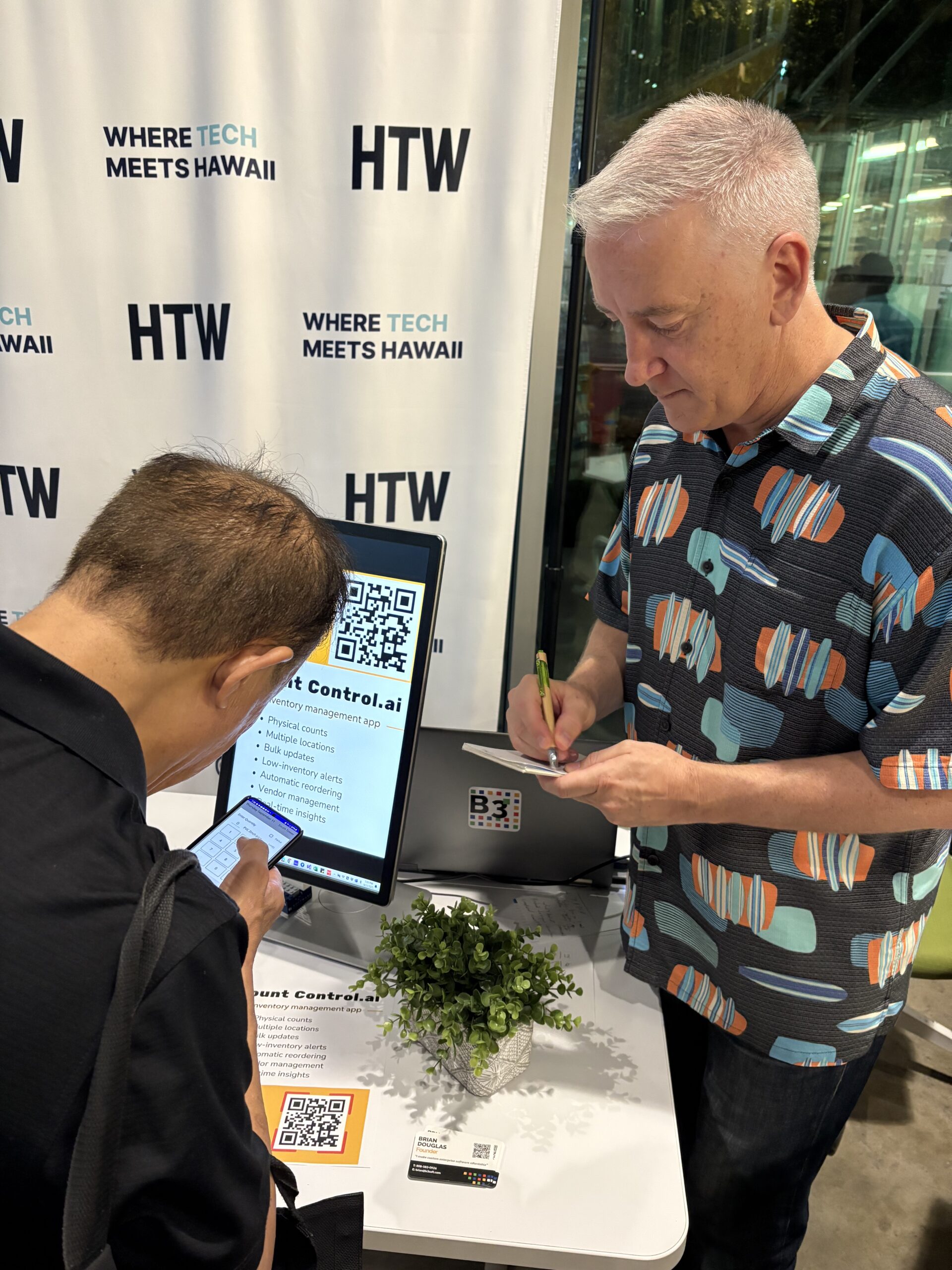 Picture from Beta Brews event where a participant tests the Count Control app while Brian takes notes