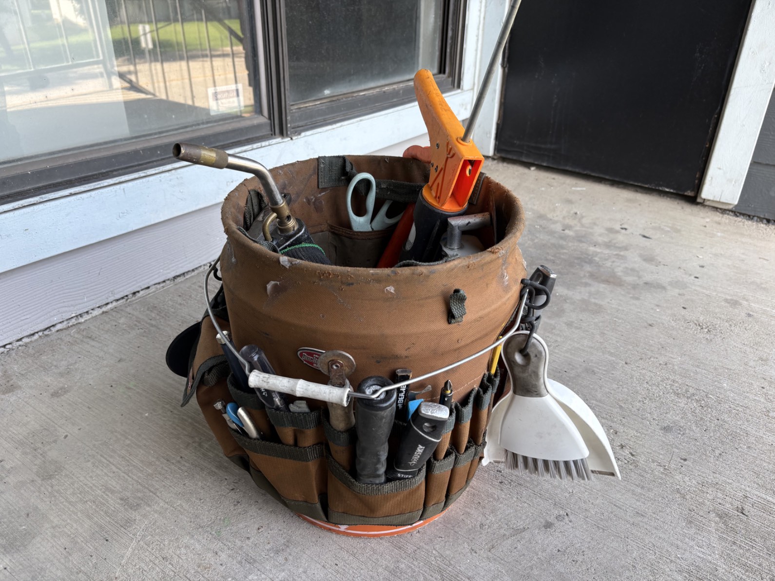 Field service management software research photo of field service tech's utility bucket full of tools.