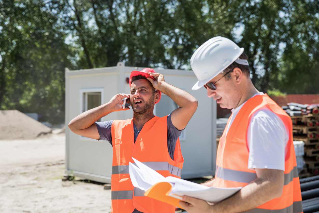 Two construction workers are trying to solve a construction job over the phone.