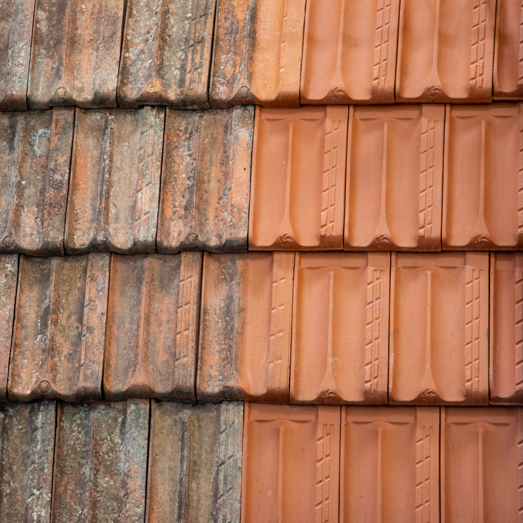Before and after pressure washing work - one side is a mess, the other side is clean shingles.