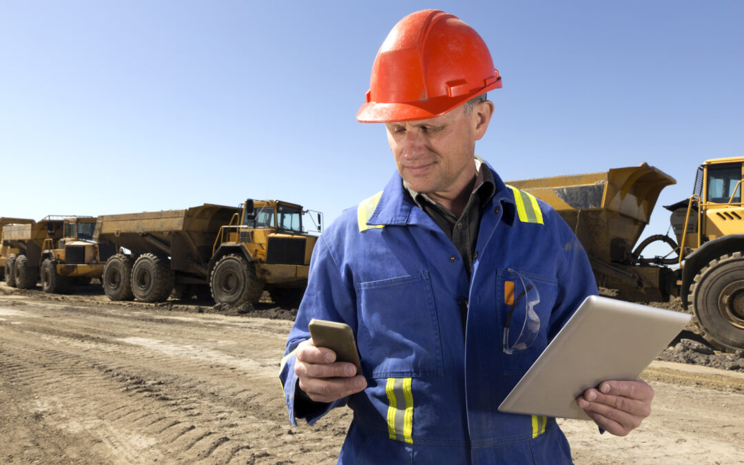 Construction worker with an orange hard hat using a Cost-saving software for construction businesses