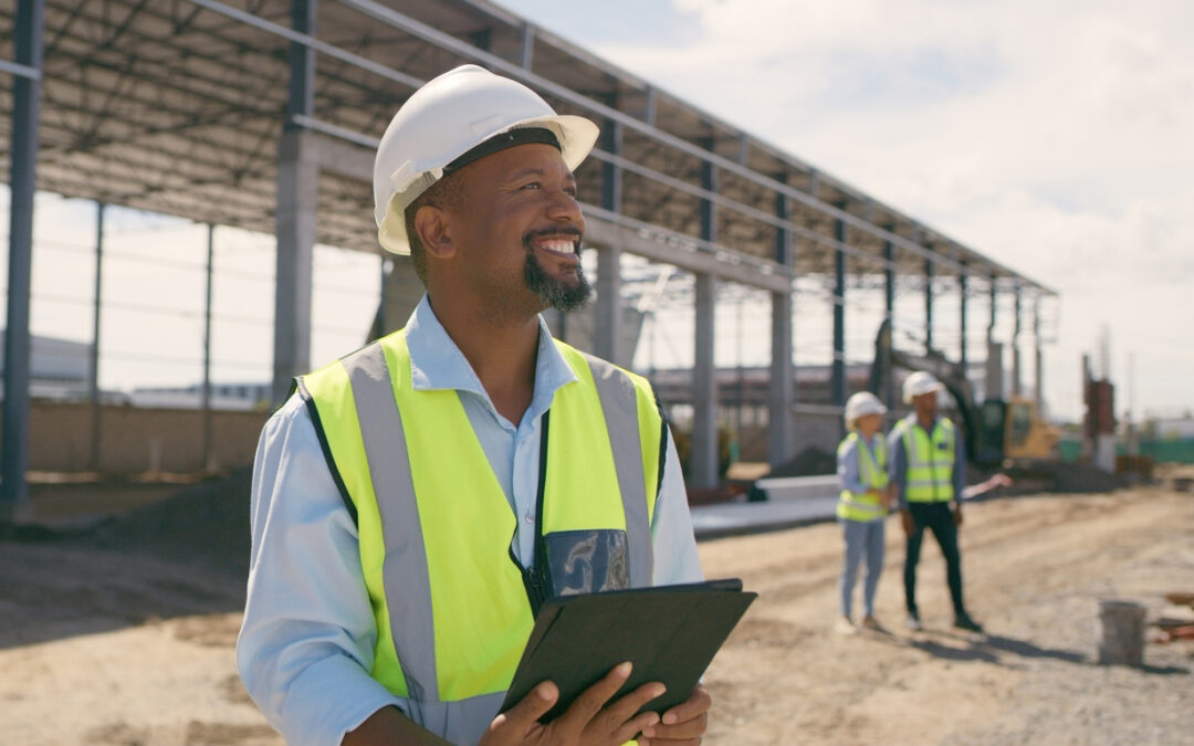 Contractor at a construction site, using a tablet for project management and scalability