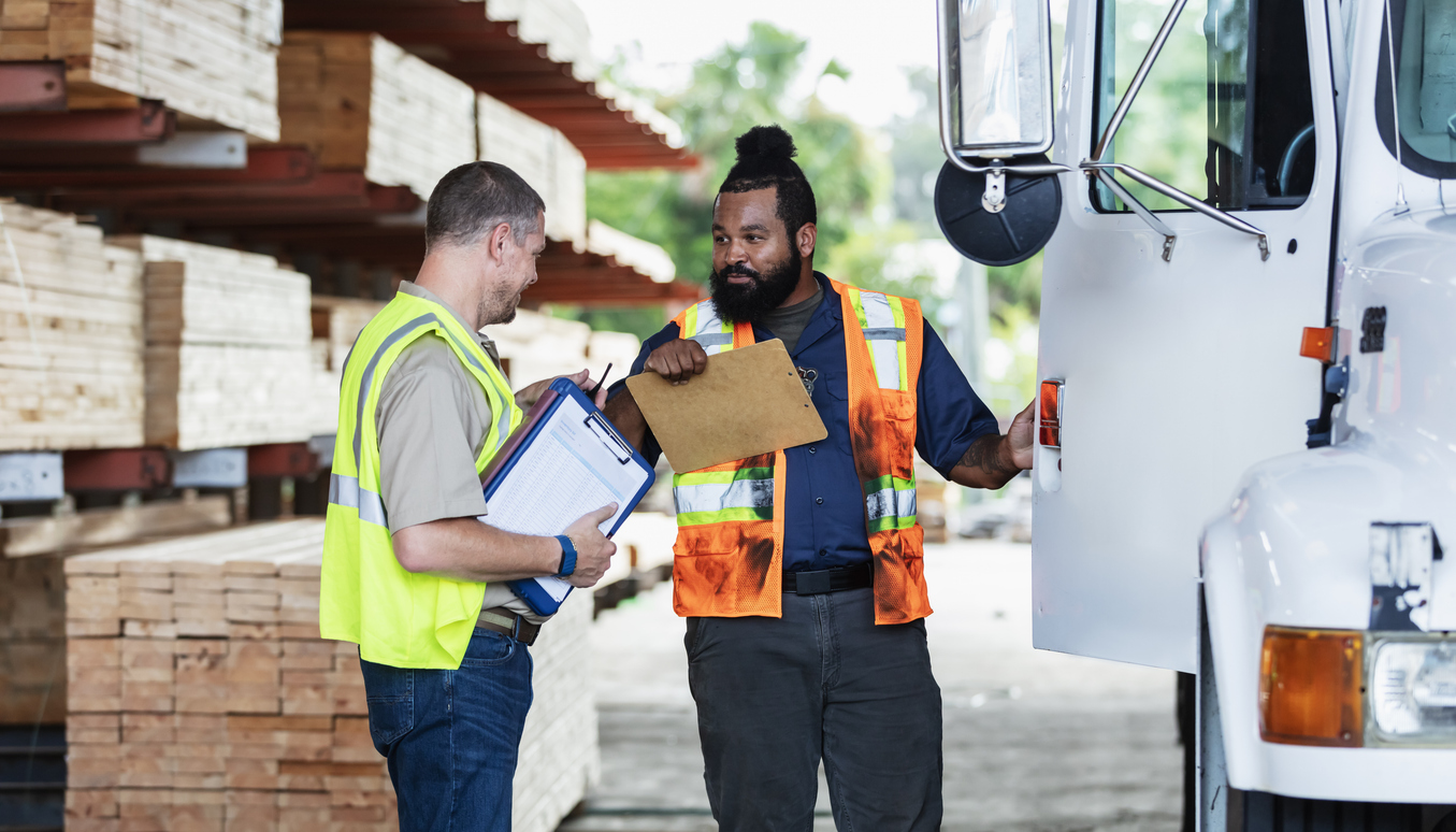Two men in construction clothes outside of a truck Managing an Inventory delivery for a construction project
