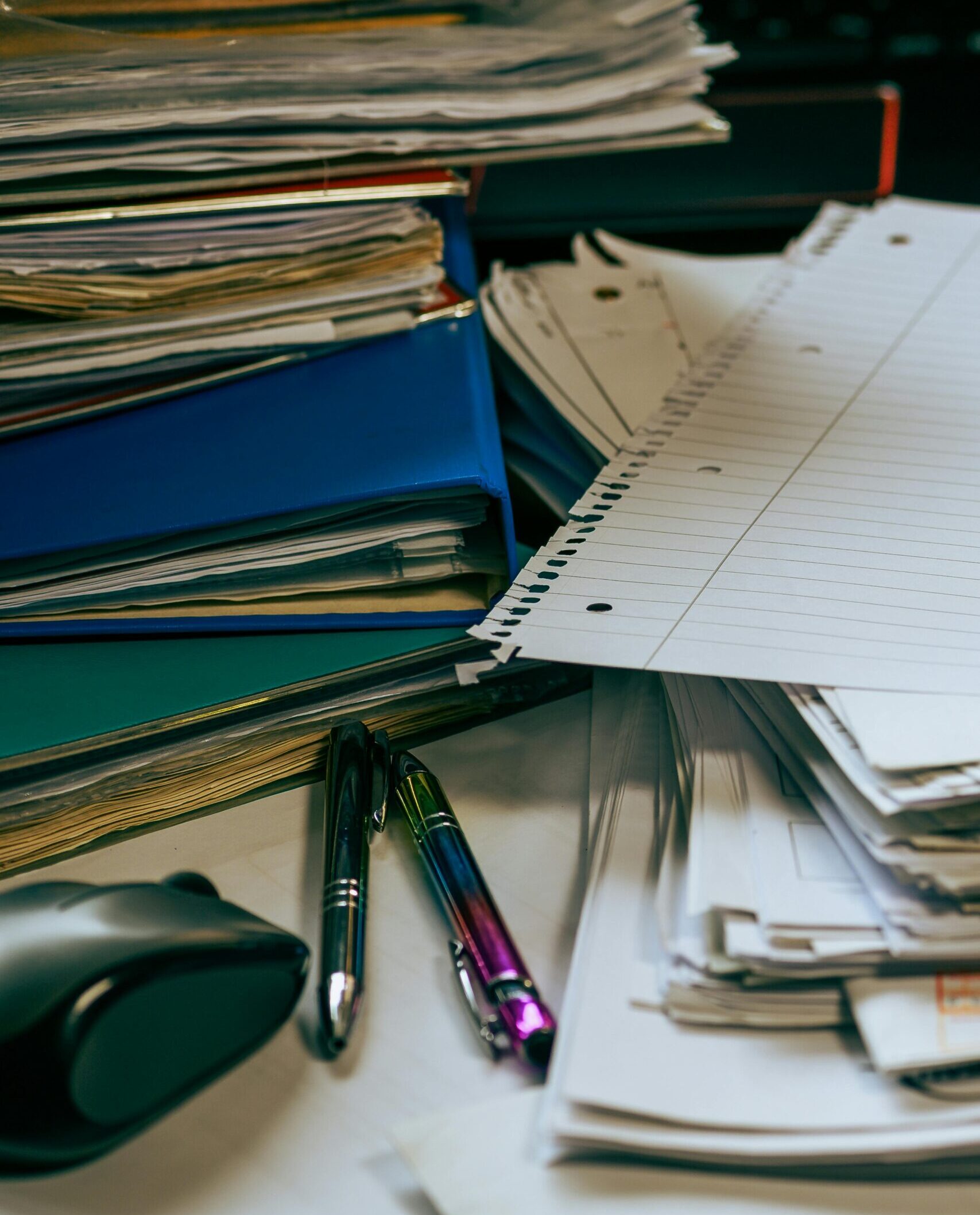 Stack of disorganized paperwork obstructing solutions for managing construction inefficiencies